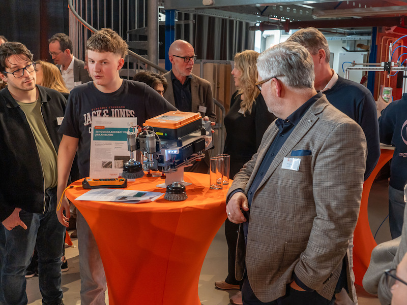 Student Bram geeft tijdens de innovatiebeurs tijdens de Scale Innovation Award uitleg over zijn innovatie aan aanwezigen