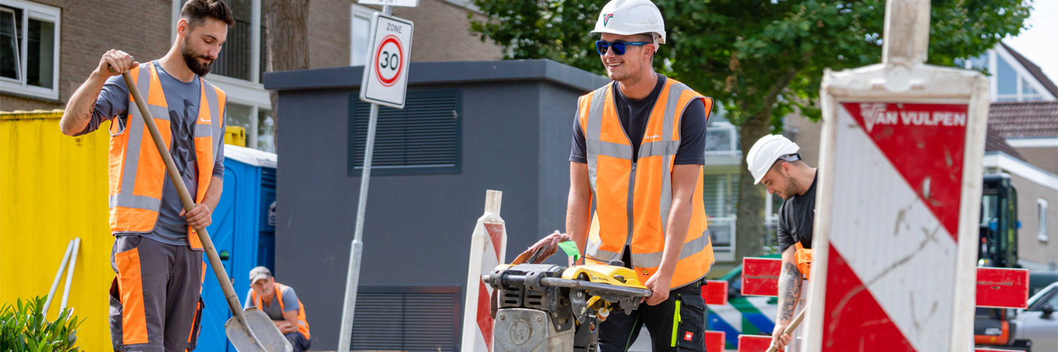 Twee medewerkers aan het werk in de buurt van een trafohuisje