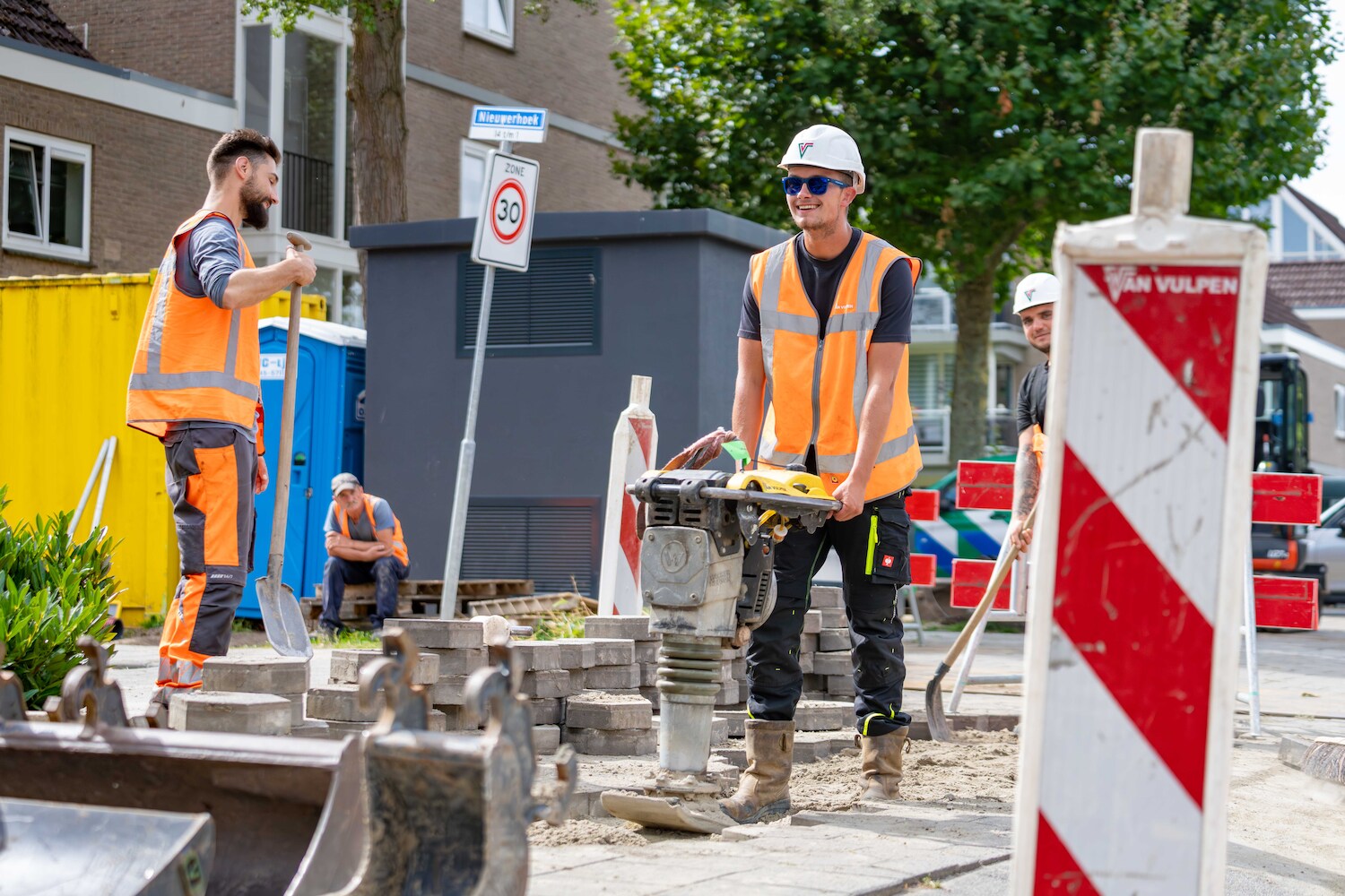 Twee medewerkers aan het werk in de buurt van een trafohuisje