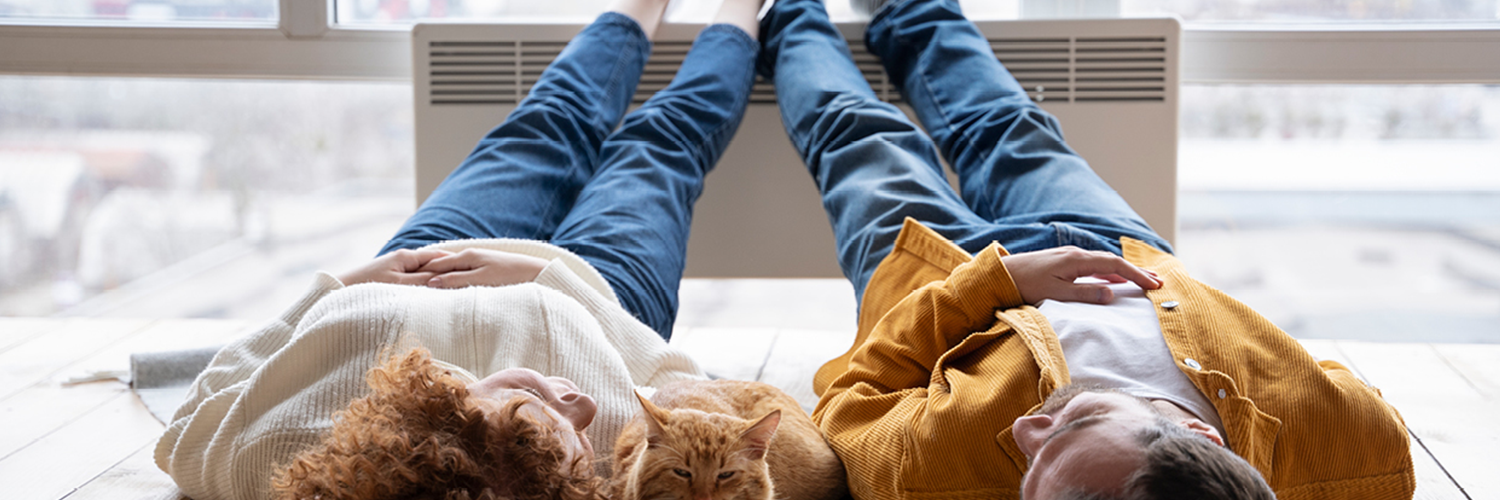 Man, vrouw en huisdier bij verwarming in een appartement