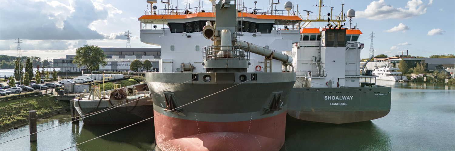 Vooraanzicht van drie grote schepen langs de kade