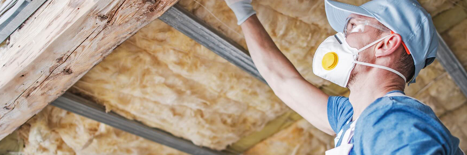 Man met masker werkt aan dakisolatie