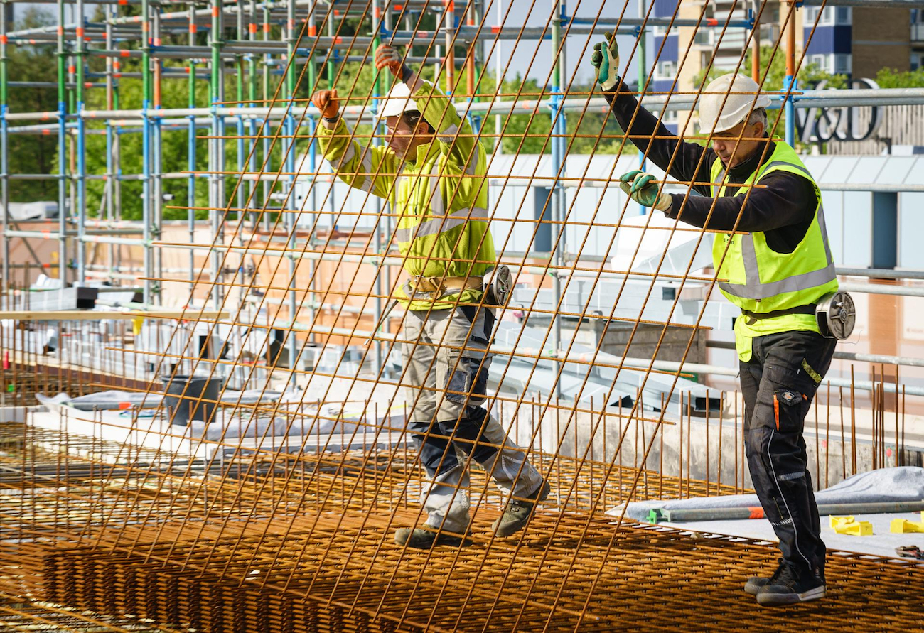 Een foto van twee mannen die bezig zijn met het bouwen van een gebouw